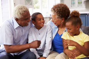 a family sitting on a couch smiling at each other.