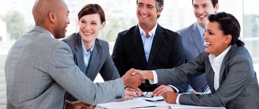 a group of business people shaking hands at a table.
