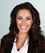 a woman with long brown hair and a black blazer.